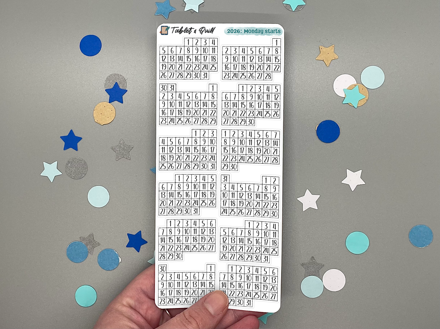Sheet of pre-printed 2026 Monday start calendars on a gray background with decorative stars.