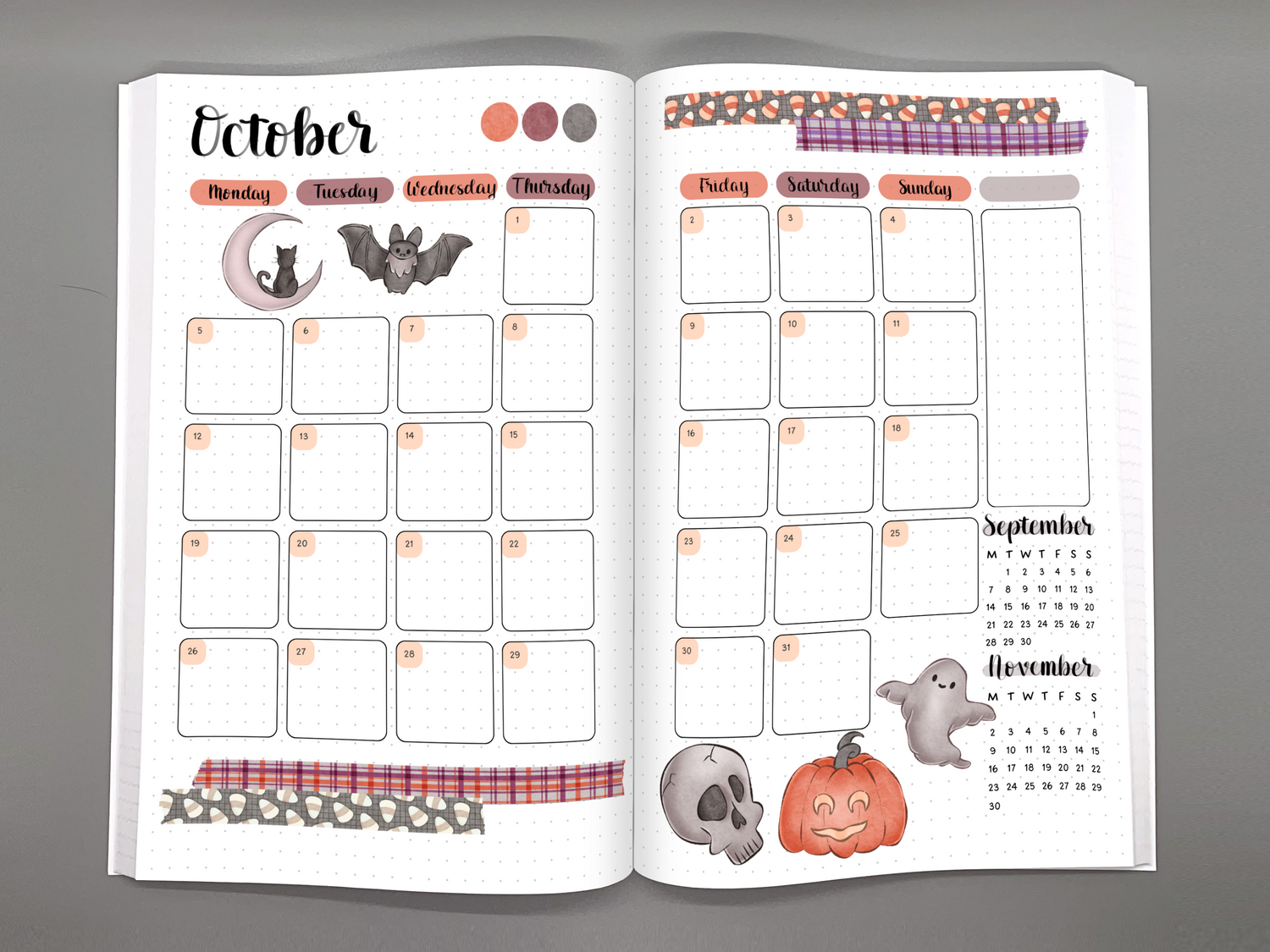 Open bullet journal inspired planner showing a Halloween themed monthly calendar spread.
