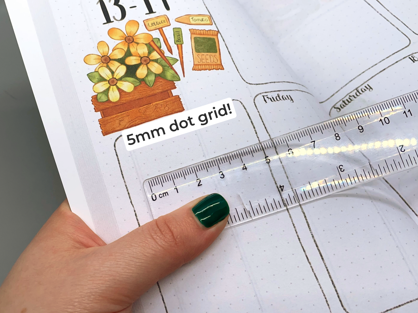 Closeup of hand holding a ruler over a planner page with '5mm dot grid' text.