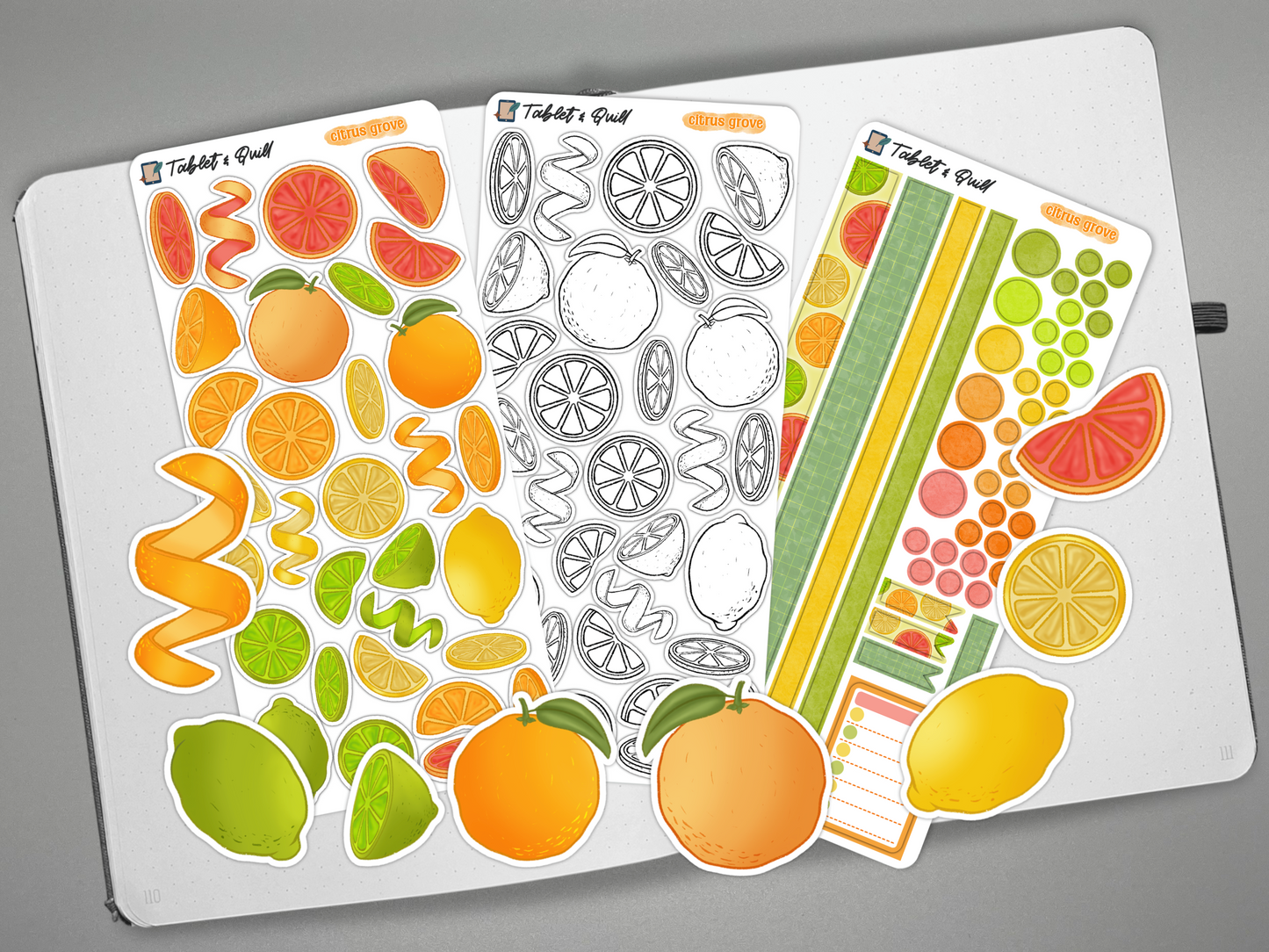 Set of colorful citrus themed bullet journal stickers on an open bullet journal over a gray background with decorative elements.