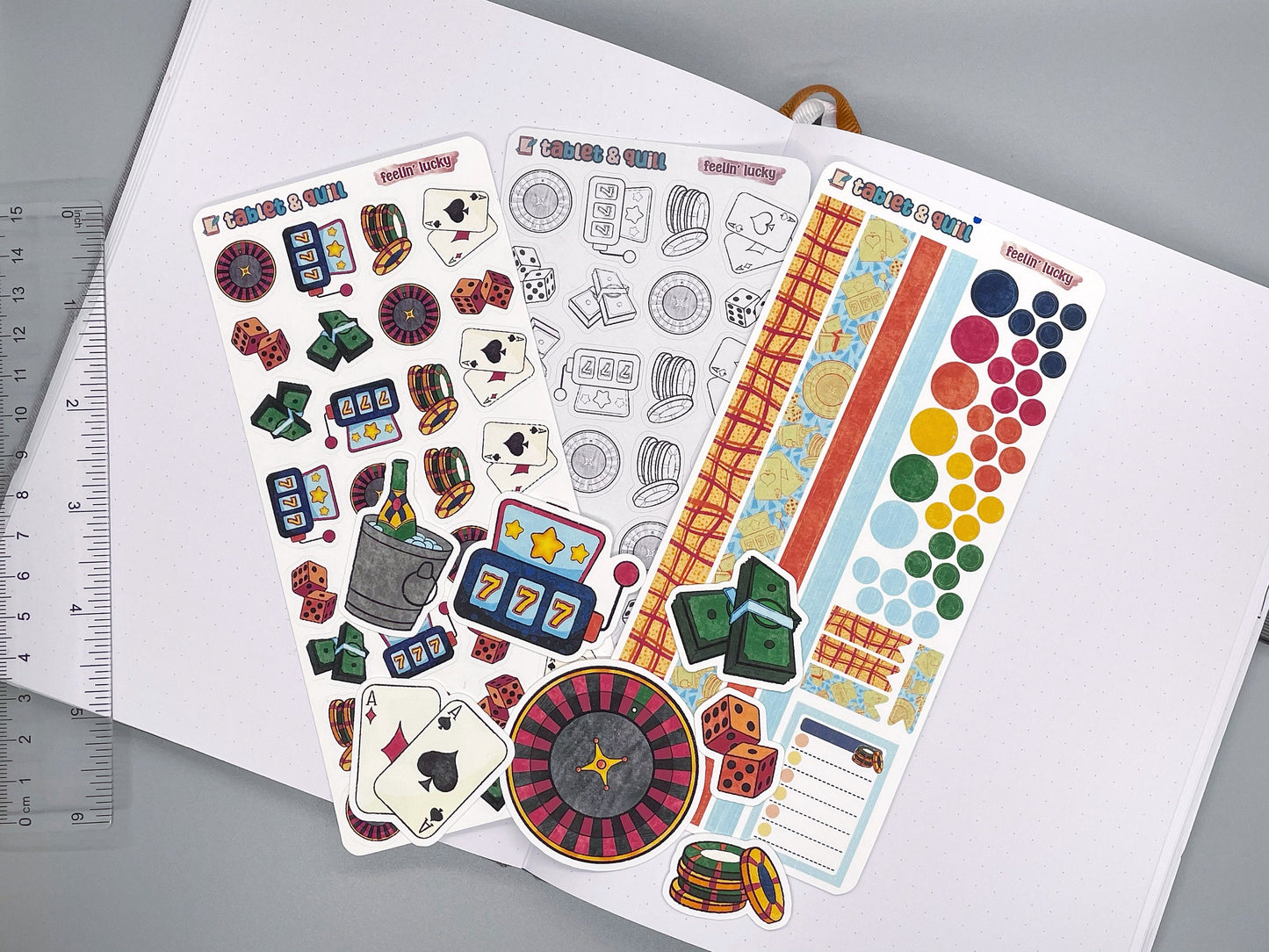 An overview image of casino themed stickers, including a color sticker sheet, a colorable sticker sheet, a decorative sticker sheet, and die cut sticker flakes. Ruler on the left.