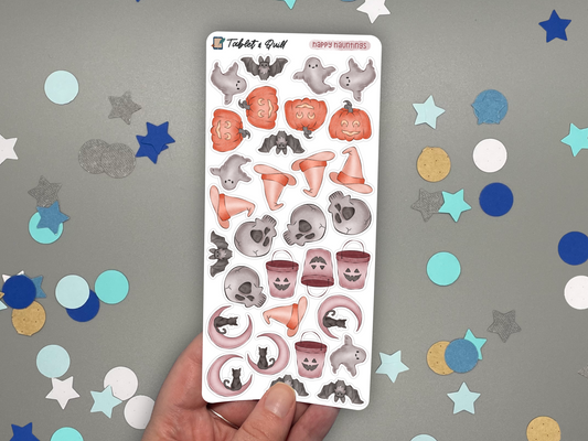 Sheet of Halloween-themed stickers held over a gray background with confetti