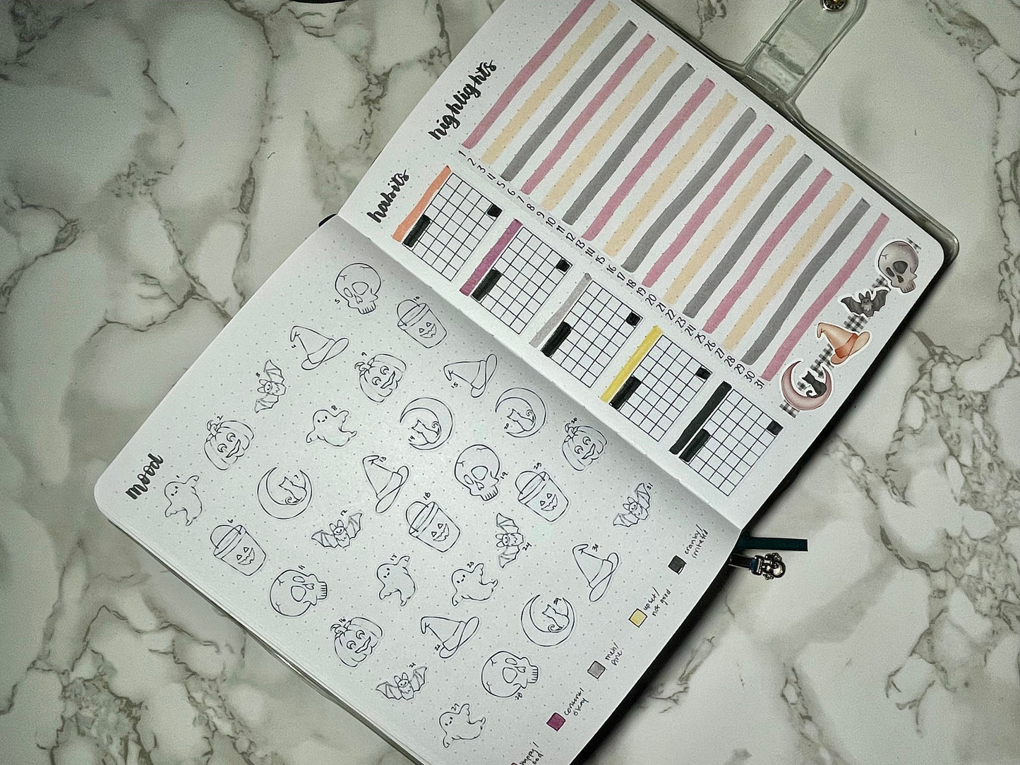 Bullet journal with Halloween-themed stickers and a marble surface