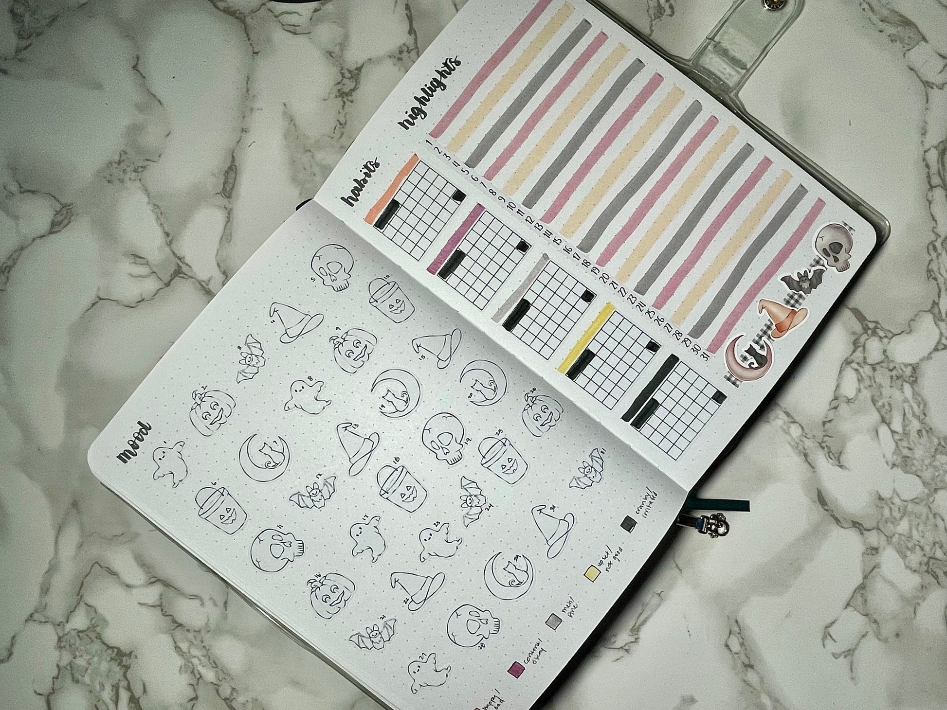 Bullet journal with Halloween-themed stickers and a marble surface