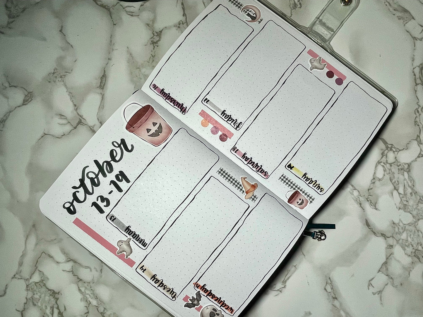 Halloween themed bullet journal with a weekly layout on a marble surface