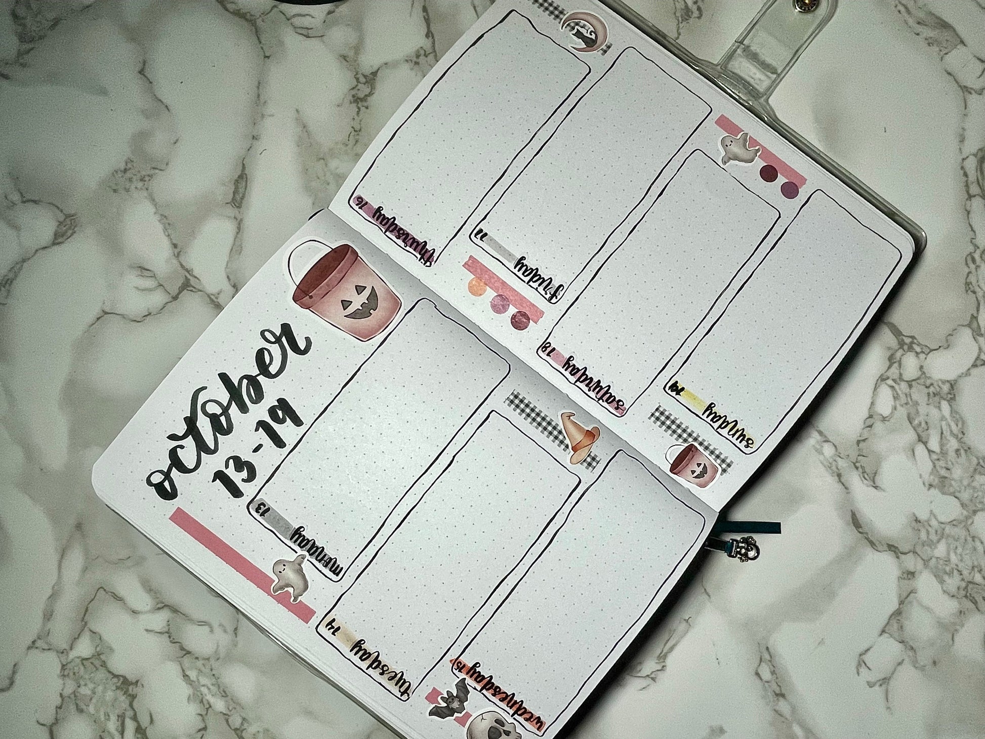Halloween themed bullet journal with a weekly layout on a marble surface