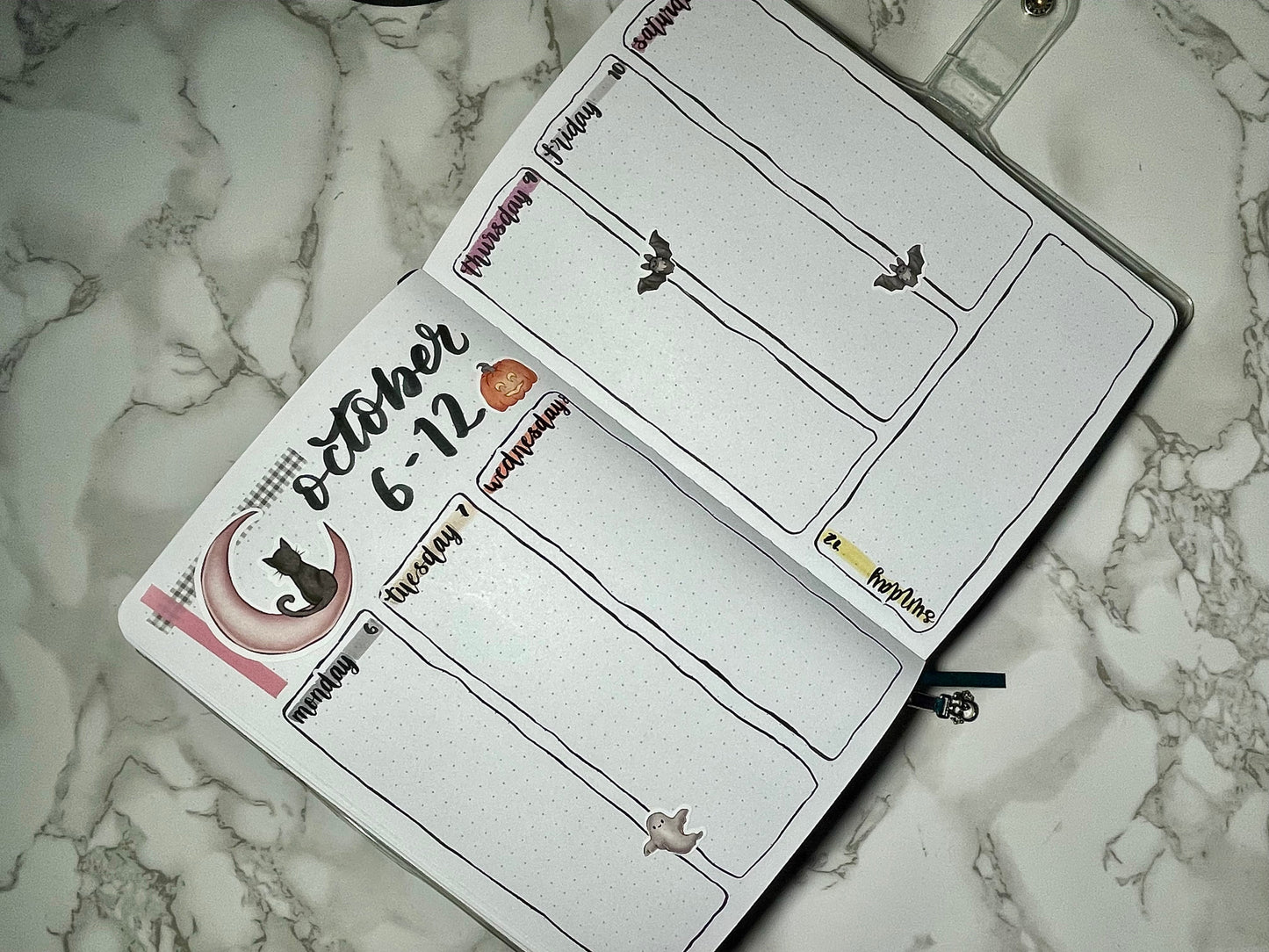Halloween themed bullet journal weekly spread on a marble surface