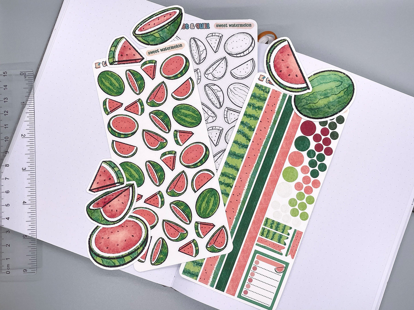 An overview image of watermelon themed stickers, including a color sticker sheet, a colorable sticker sheet, a decorative sticker sheet, and die cut sticker flakes. Ruler on the side.
