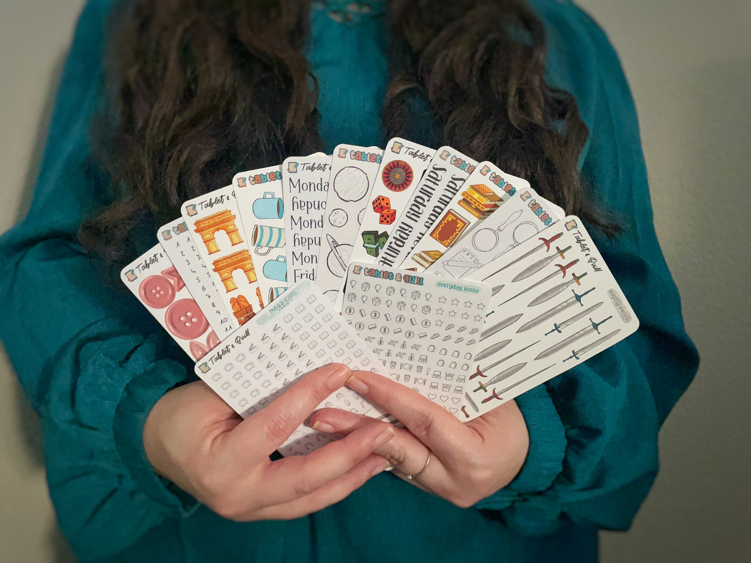 Person holding a set of planner stickers with various designs.