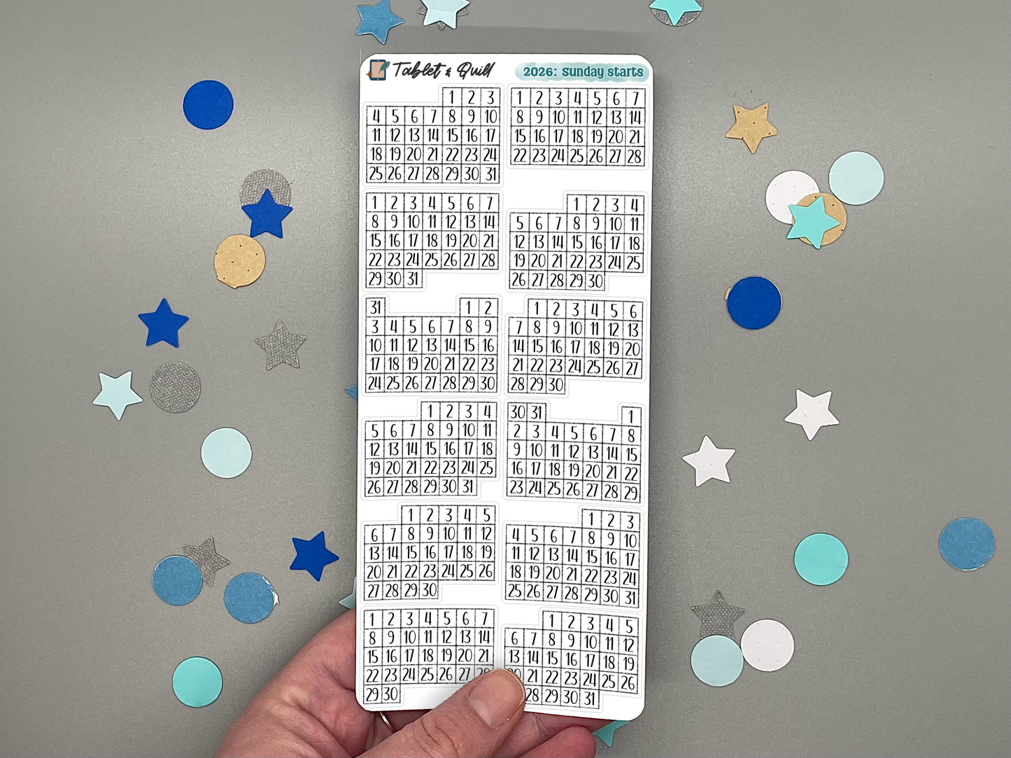 Sheet of pre-printed 2026 Sunday start calendars on a gray background with decorative stars.