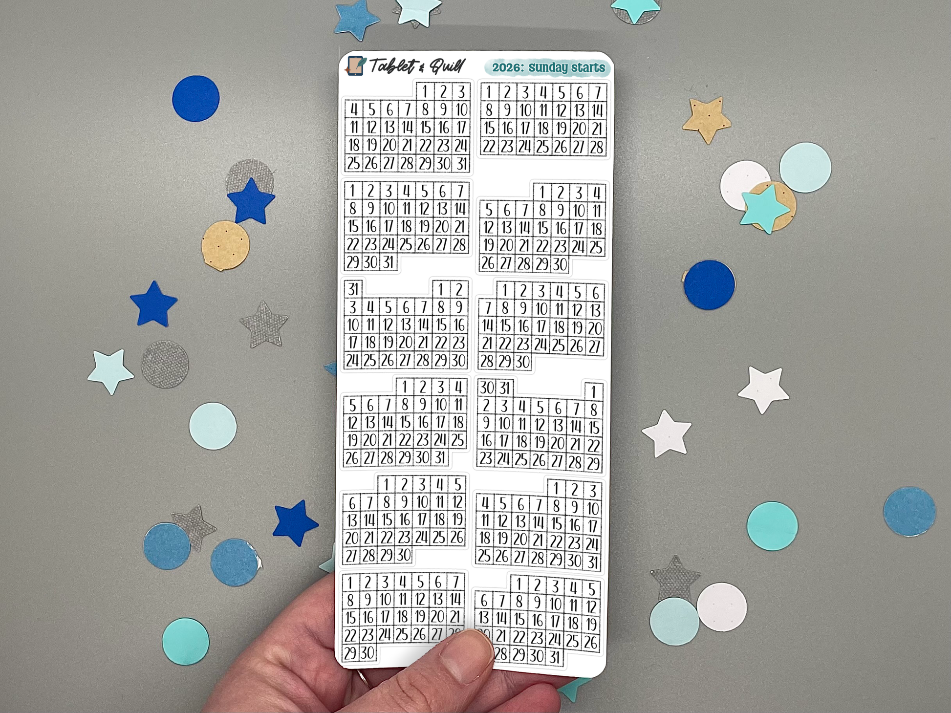 Sheet of pre-printed 2026 Sunday start calendars on a gray background with decorative stars.
