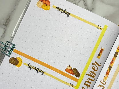 Open bullet journal showing a two page pumpkin themed weekly spread using script weekday stickers.