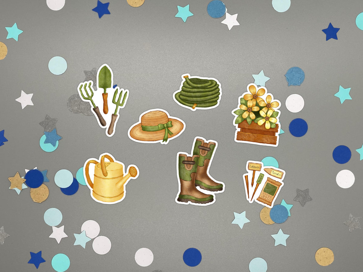 A set of garden-themed stickers arranged on a gray background with confetti. The stickers include a seed packet and markers, a coiled hose, a straw hat with a green ribbon, a flower box with yellow flowers, a watering can, a pair of green boots, and gardening tools.