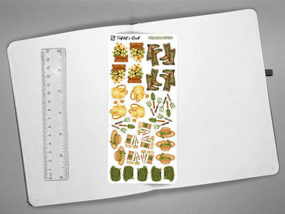 Garden themed sticker sheet on an open journal with a ruler on the left for scale all on a gray surface.