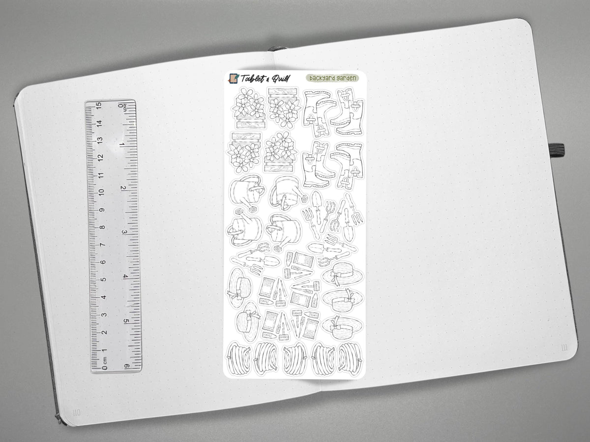 Black and white garden themed sticker on an open journal with a ruler for scale on the left, all over a gray surface.