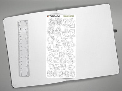 Black and white garden themed sticker on an open journal with a ruler for scale on the left, all over a gray surface.