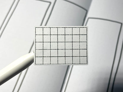 Closeup of a blank mini calendar. The background is a bullet journal weekly spread.