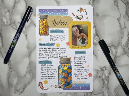 About me page with two pens on a marble surface. The page is decorated with koi stickers, star stickers, paper star in jars stickers, and washi tape.