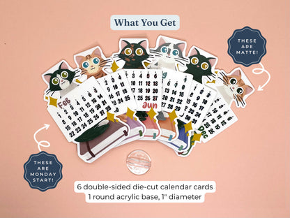 A set of six die-cut calendar cards featuring cartoon cat illustrations and monthly grids, arranged on a peach background with text describing the contents and a round acrylic base.