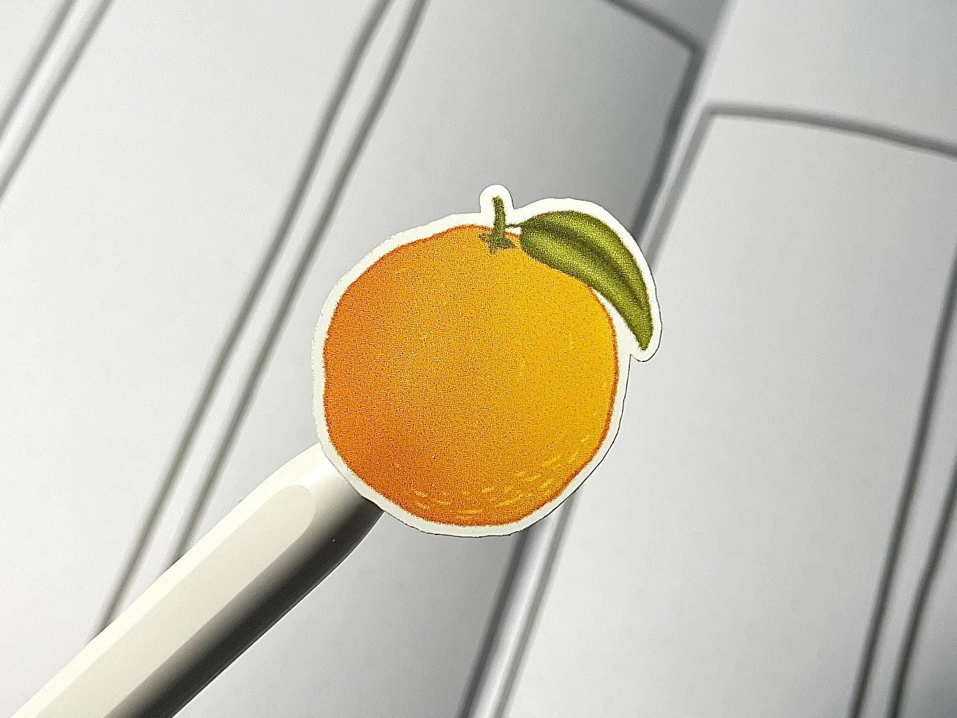 Closeup of a color citrus themed sticker over a weekly bullet journal spread.