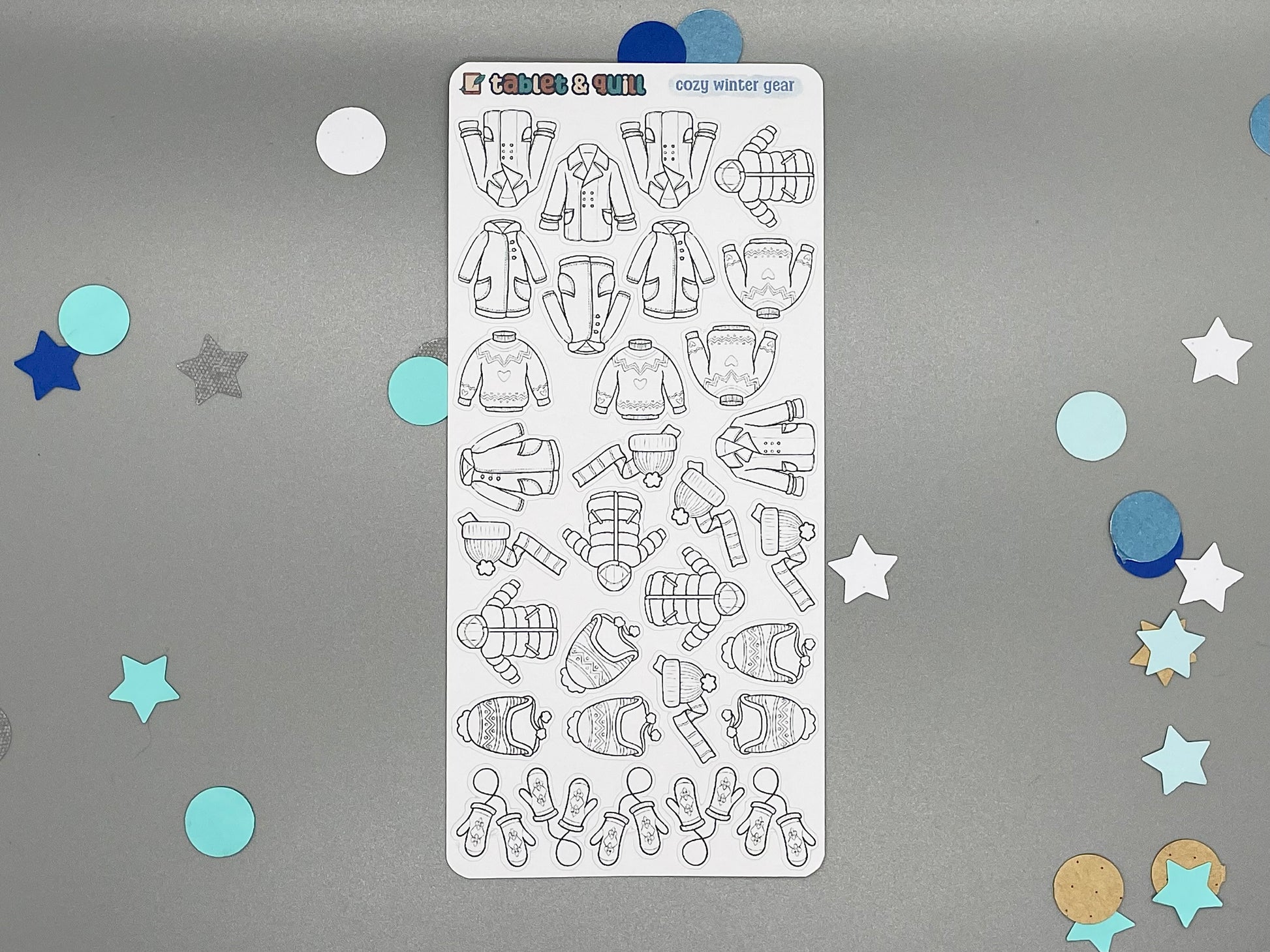 Sticker sheet of winter clothes themed stickers on a gray background with decorative stars and circles.