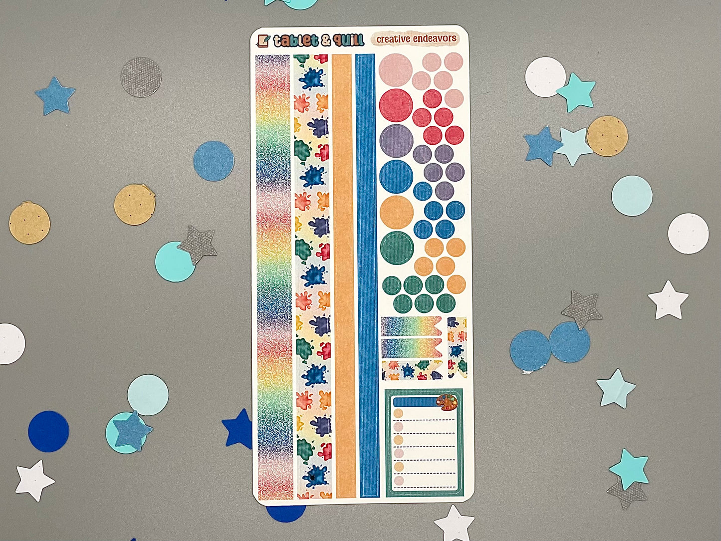 Sticker sheet with matching design as our art supplies themed stickers on a gray background with decorative stars and circles.