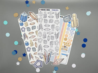 An overview image of crystals themed stickers, including a color sticker sheet, a colorable sticker sheet, a decorative sticker sheet, and die cut sticker flakes.