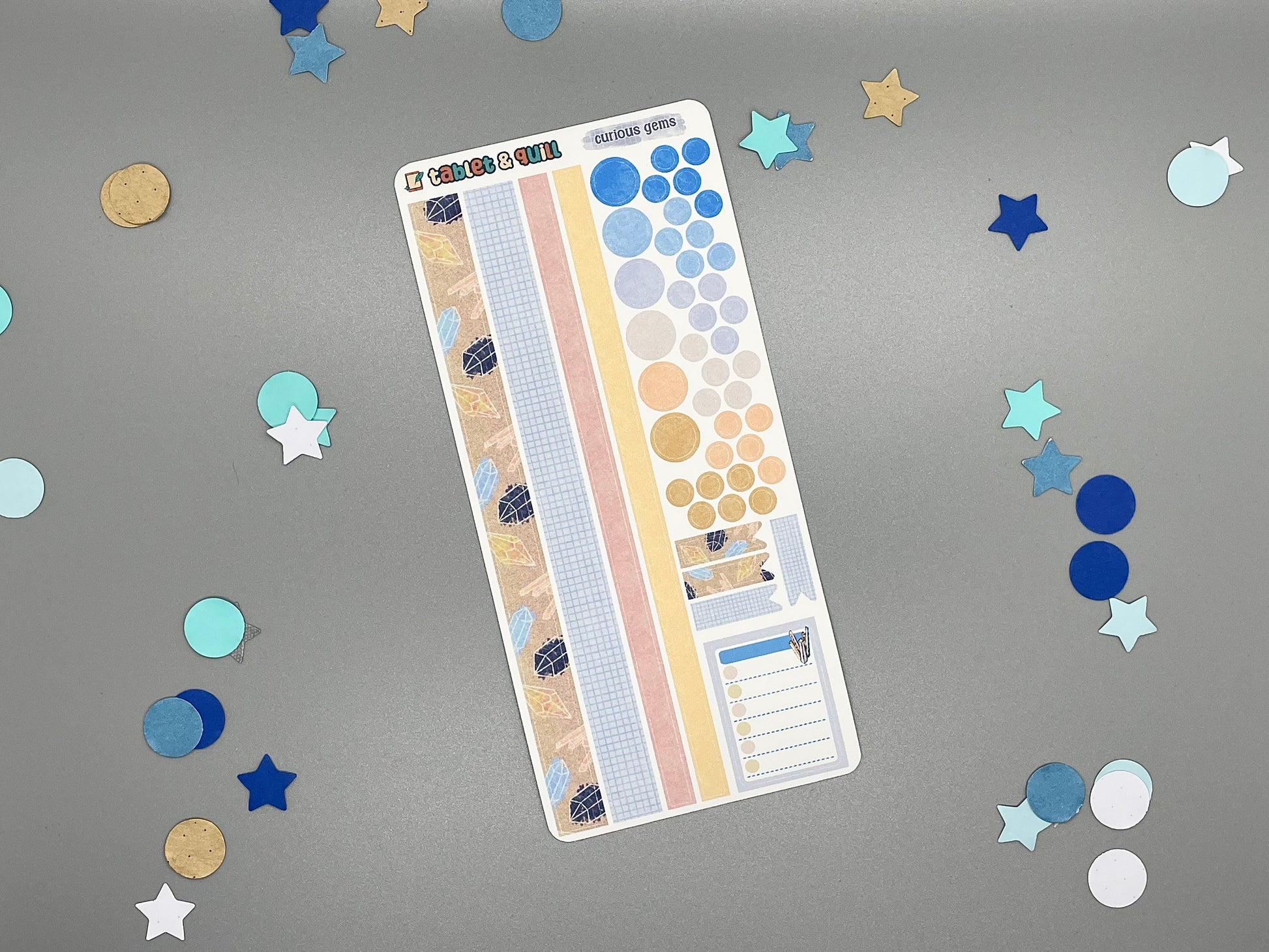 Sticker sheet with matching design as our crystal themed stickers on a gray background with decorative stars and circles.