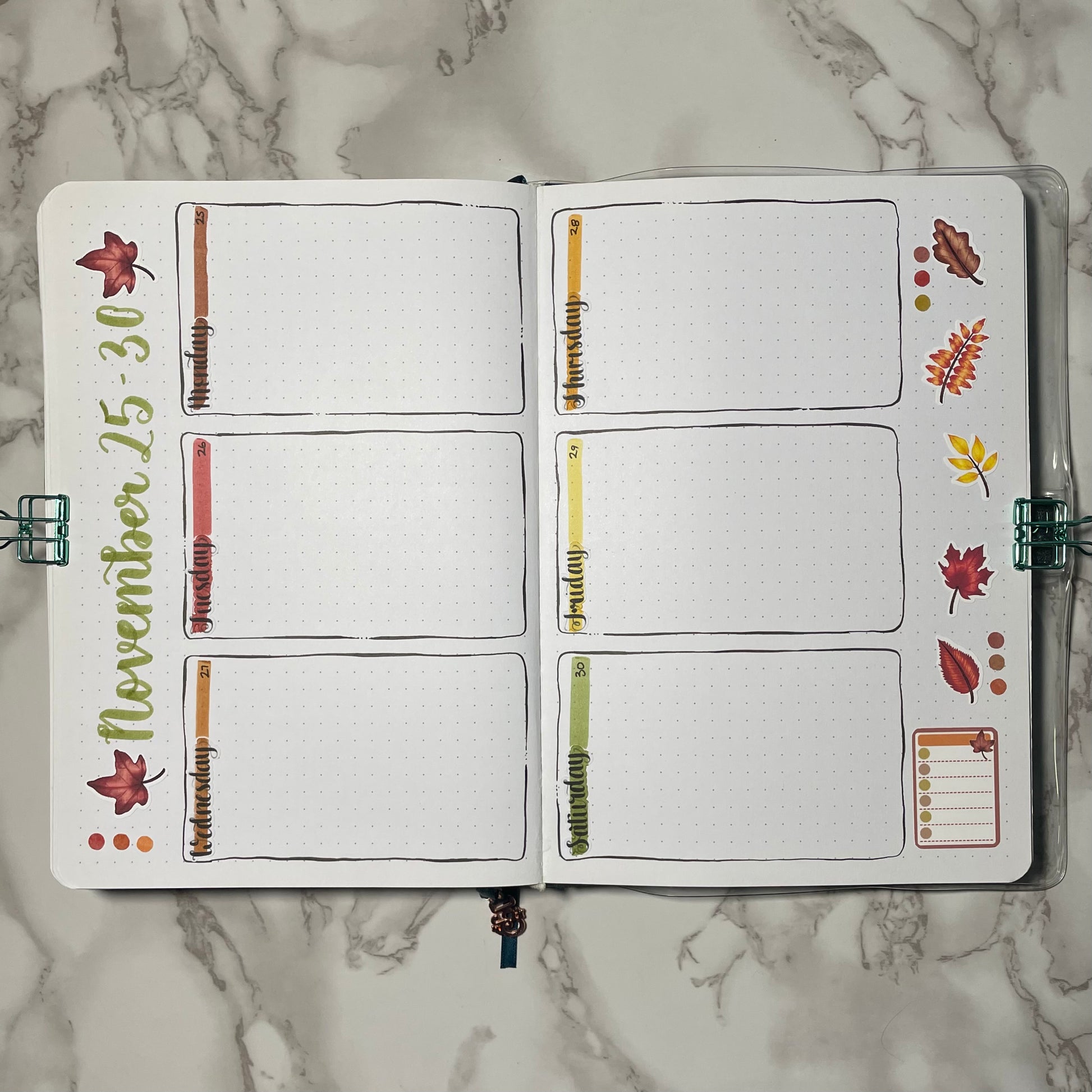 Weekly bullet journal autumn leaves themed spread using weekday stickers.