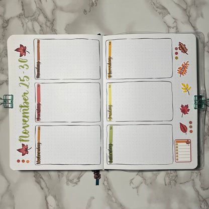 Weekly bullet journal autumn leaves themed spread using weekday stickers.