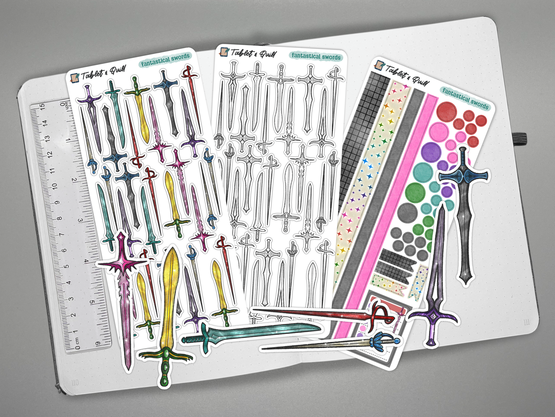 Set of fantasy sword stickers on a journal with a ruler for scale.