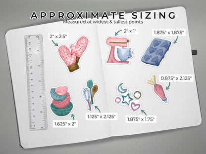 Baking themed die cut stickers on an open journal with measurements and ruler for scale on the left, all on a gray surface.