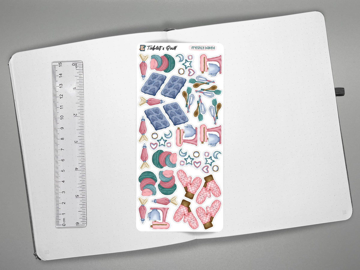 A baking themed sticker sheet in color on an open journal with a ruler for scale on the left, all over a gray background.