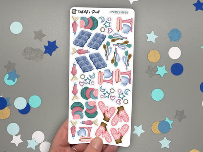 A hand holding a baking themed sticker sheet in color over a gray surface with confetti.