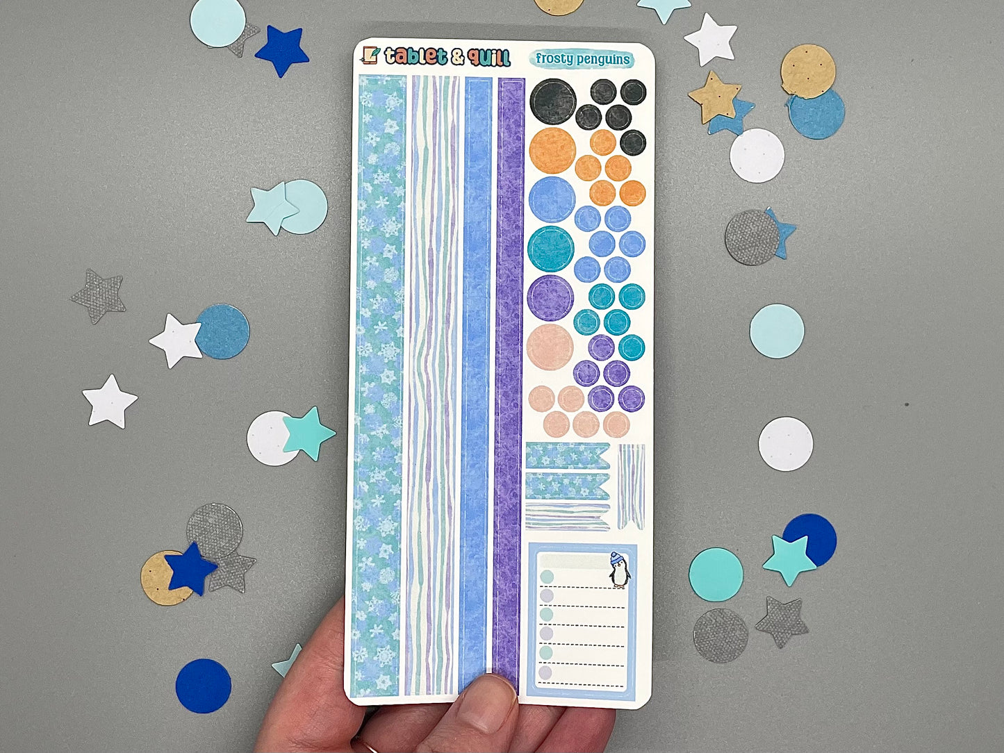 Sheet of decorative stickers with various patterns held over a gray background with scattered stickers.