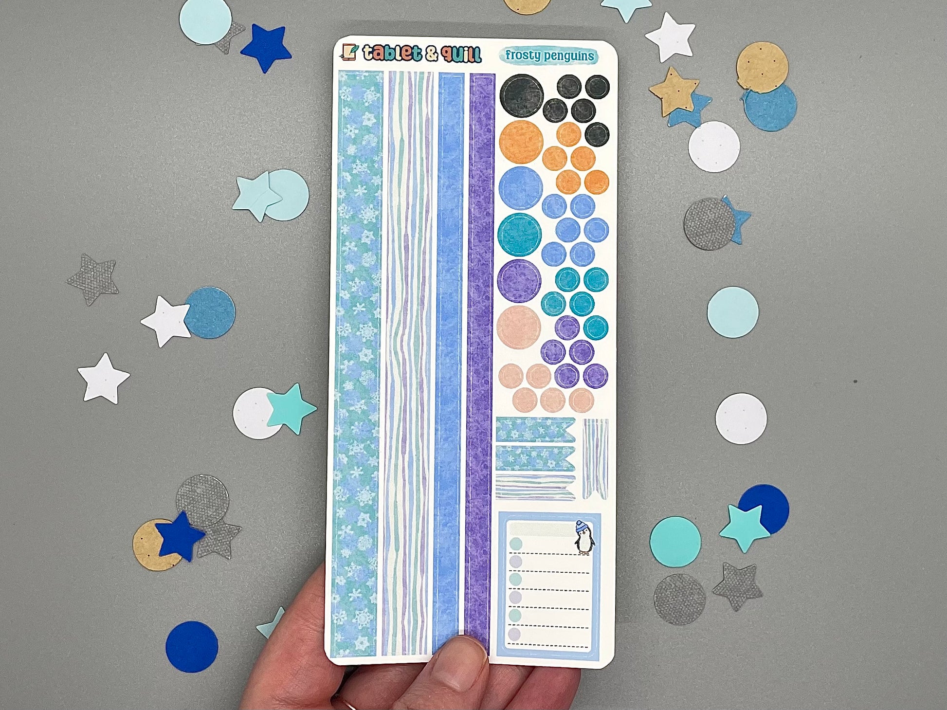 Sheet of decorative stickers with various patterns held over a gray background with scattered stickers.