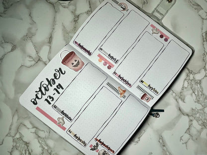 Halloween themed bullet journal with a weekly layout on a marble surface