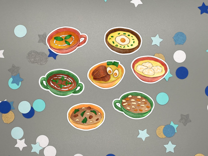 Seven illustrated soup stickers arranged on a gray background with scattered star and circle confetti. The stickers show colorful soups and stews illustrations including soups, noodles, dumplings, and meatballs in different bowl colors.