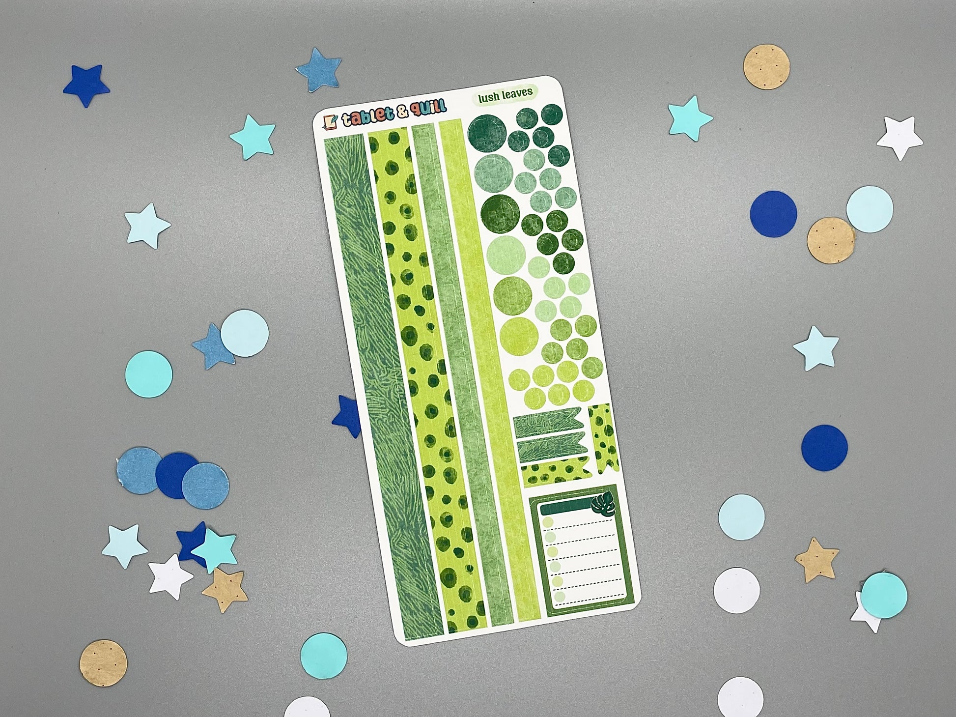 Sticker sheet with matching design as our leaves themed stickers on a gray background with decorative stars and circles.