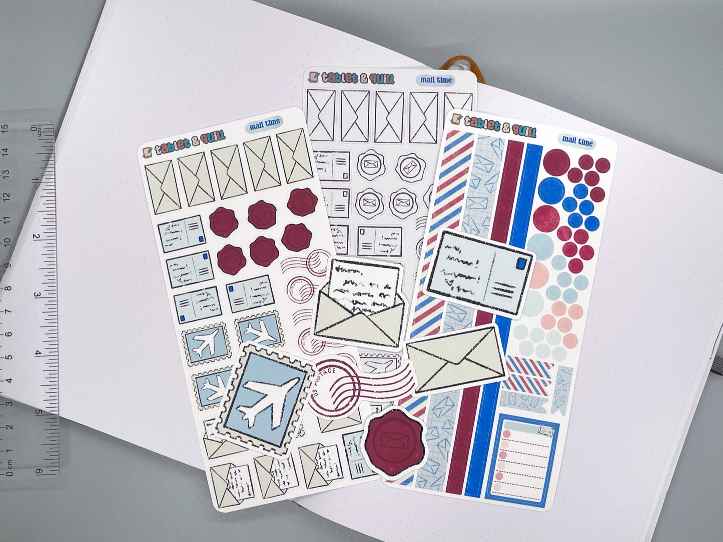 Set of mail themed stickers for bullet journals and planners. Set includes colorable sticker sheet, decorative sticker sheet, color sticker sheet, and die cut sticker flakes. Ruler for scale on the left.