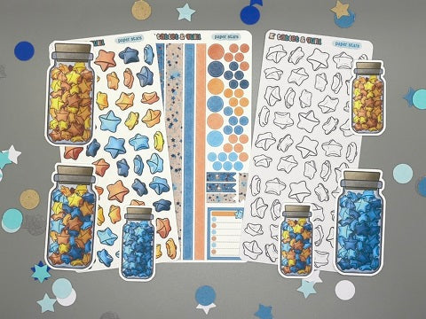 An overview image of paper stars themed stickers, including a color sticker sheet, a colorable sticker sheet, a decorative sticker sheet, and die cut sticker flakes.