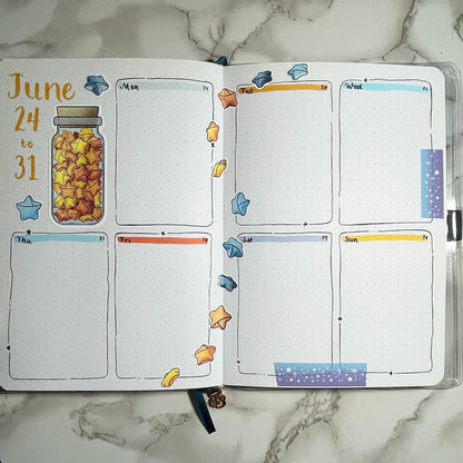 An overview image of a paper stars themed bullet journal weekly spread.
