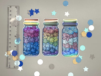 Holographic laminated pride stickers. Paper stars in a jar. Rainbow, bisexual, transgender flag colors.