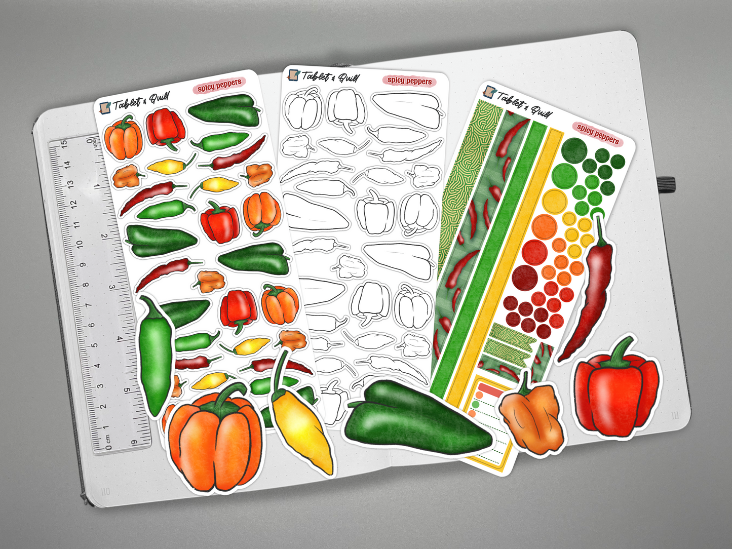 Set of pepper-themed stickers on a journal with a ruler for scale, on a gray background.