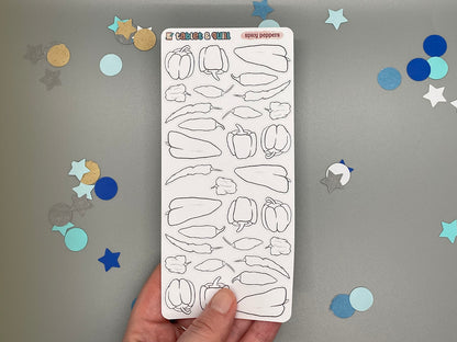 Sheet of diy color pepper-shaped stickers held by a hand with confetti on a gray background