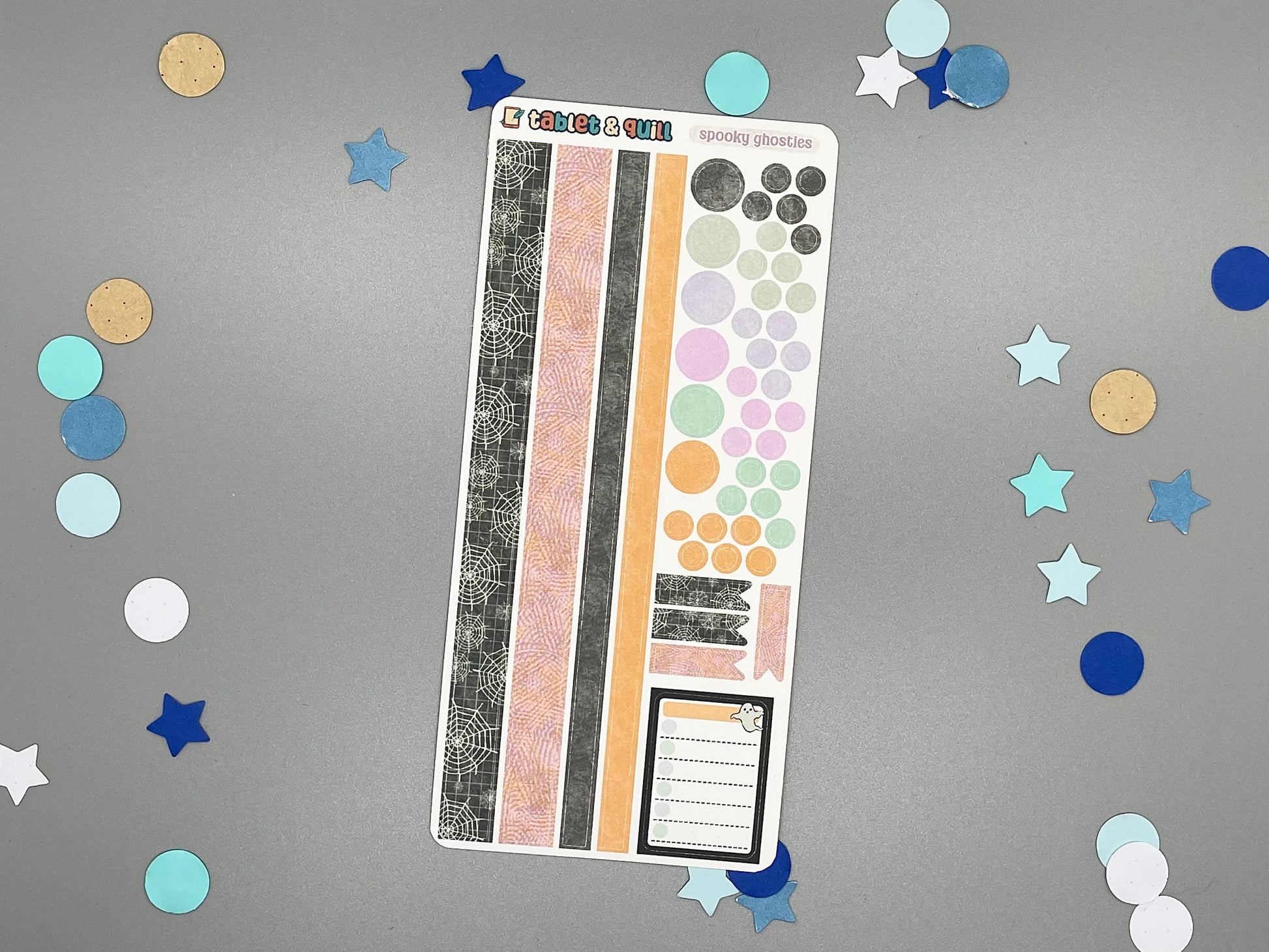 Sticker sheet with matching design as our ghost themed stickers on a gray background with decorative stars and circles.