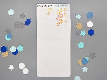 Stars and sparkles DIY color sticker sheet on a gray background. Some sparkles have been colored with markers and removed from the sheet.