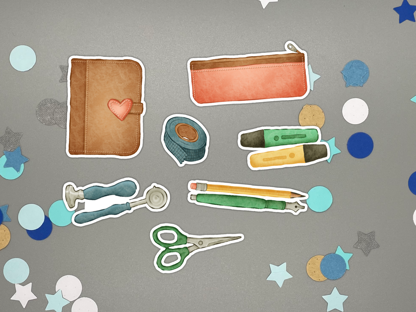 Collection of stationery themed stickers on a gray background with confetti.