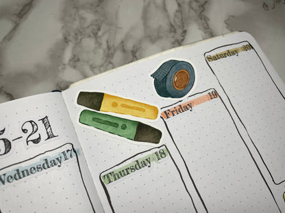 Open bullet journal weekly spread with custom header stickers and stationery themed stickers.