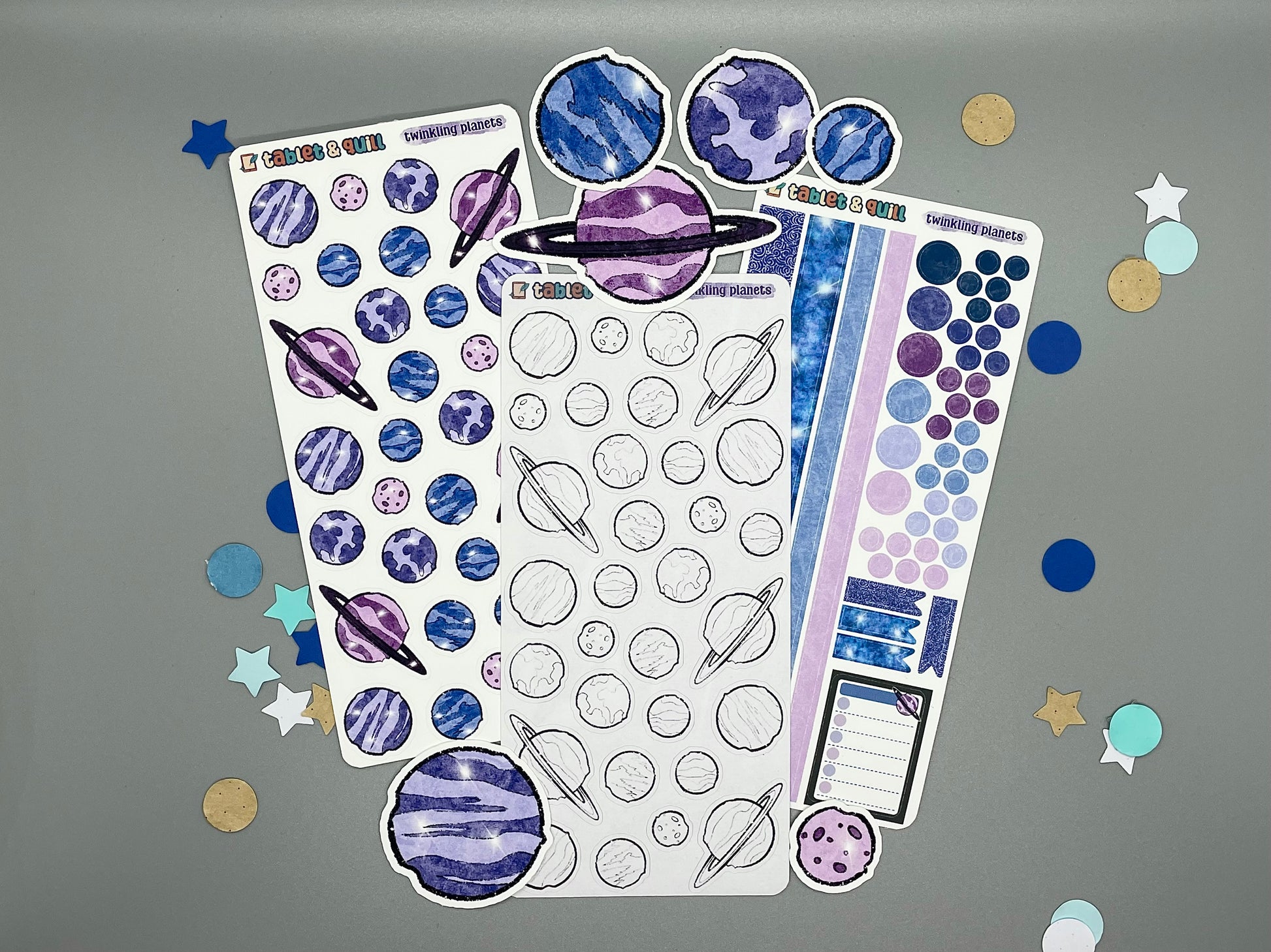 Twinkling planets sticker sheets and die cut stickers on gray background with confetti.